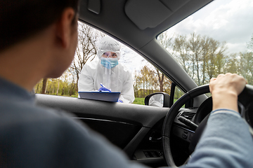 Image showing healthcare worker with clipboard and woman in car