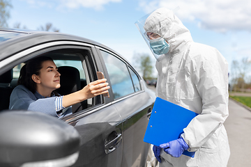 Image showing woman in car showing phohe to healthcare worker