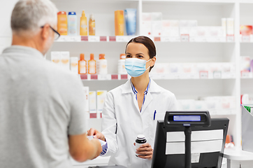 Image showing apothecary selling drug to senior man at pharmacy