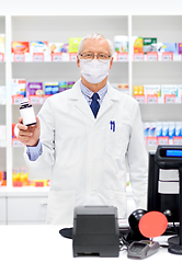 Image showing senior apothecary in mask with drug at pharmacy