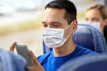 Image showing man in mask using smartphone in travel bus