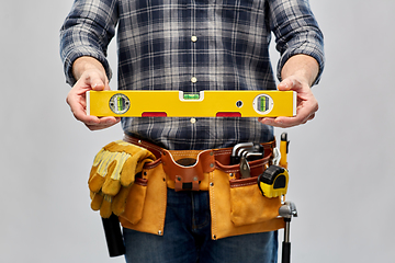 Image showing male builder with level and working tools on belt