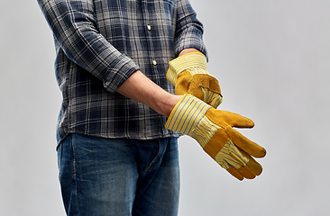 Image showing man or builder putting protective gloves on