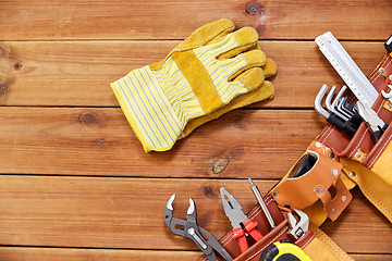 Image showing different work tools in belt on wooden boards