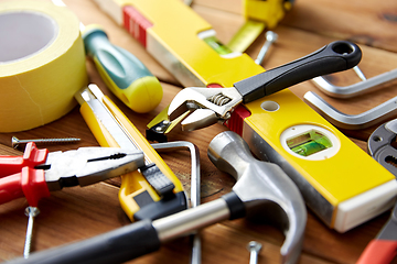 Image showing different work tools on wooden boards background