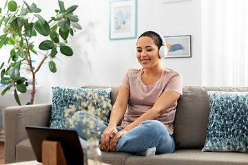 Image showing woman with tablet pc listening to music at home