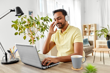 Image showing man in headphones with laptop working at home