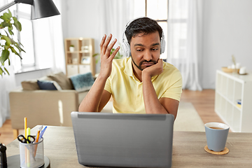 Image showing man in headphones with laptop working at home