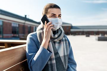 Image showing woman in face mask calling on smartphone in city