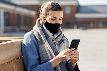 Image showing woman in face mask with smartphone in city