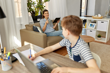 Image showing mother with tablet pc talking to son at home