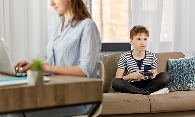 Image showing boy with gamepad playing video game at home