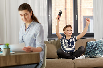 Image showing happy boy with gamepad playing video game at home