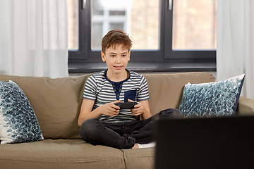 Image showing boy with gamepad playing video game at home