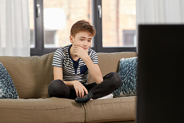 Image showing sad boy with gamepad playing video game at home