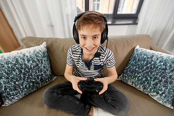 Image showing boy with gamepad playing video game at home