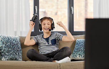Image showing boy with gamepad playing video game at home