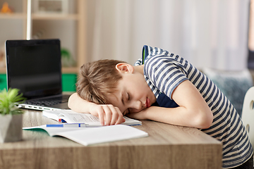 Image showing tired student boy sleeping on desk at home