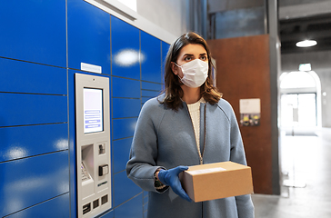 Image showing woman in mask with box at parcel machine