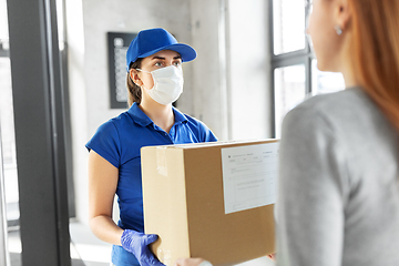 Image showing delivery girl in face mask giving parcel to woman