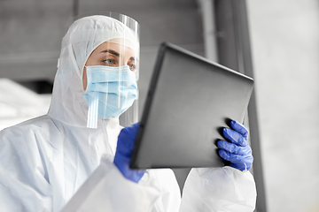 Image showing doctor in protective wear with tablet computer