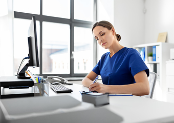 Image showing doctor or nurse with clipboard working at hospital