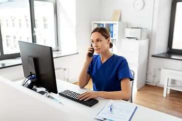 Image showing doctor with computer calling on phone at hospital