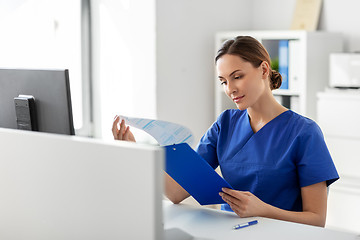 Image showing doctor or nurse with clipboard working at hospital