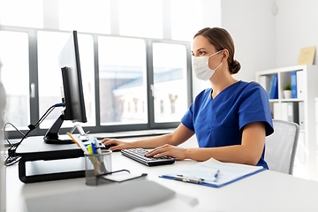 Image showing doctor or nurse in mask with computer at hospital