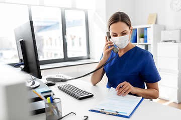 Image showing doctor with computer calling on phone at hospital