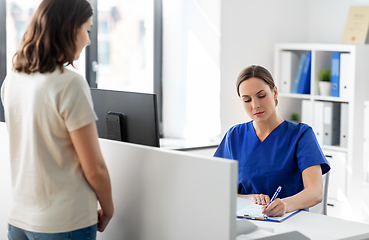 Image showing doctor with clipboard and patient at hospital