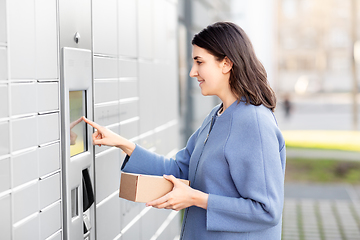 Image showing smiling woman with box at automated parcel machine