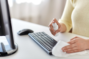 Image showing close up of woman cleaning keyboard with sanitizer