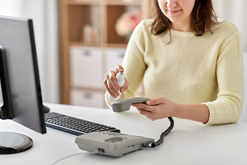 Image showing close up of woman cleaning phone with sanitizer