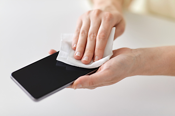 Image showing close up of hands cleaning smartphone with tissue