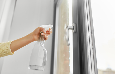 Image showing hands cleaning window handle with detergent