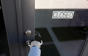 Image showing hand in glove trying to open closed office door