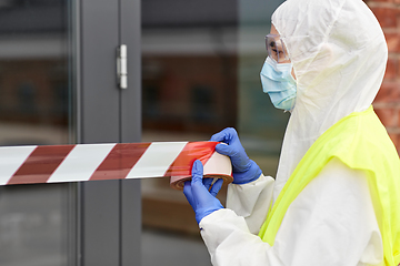 Image showing healthcare worker sealing door with caution tape