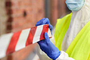 Image showing healthcare worker sealing door with caution tape