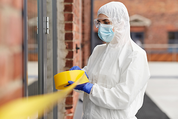 Image showing healthcare worker sealing door with caution tape