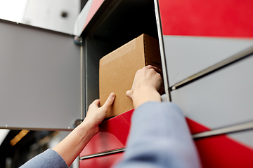 Image showing woman putting box to automated parcel machine