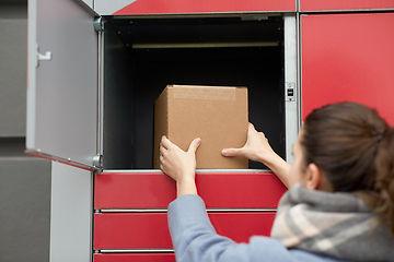 Image showing woman putting box to automated parcel machine