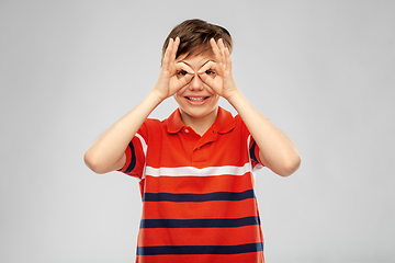Image showing happy smiling boy looking through finger glasses