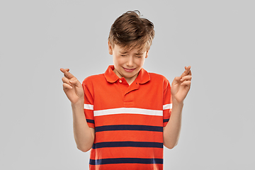 Image showing boy in red polo t-shirt holding fingers crossed