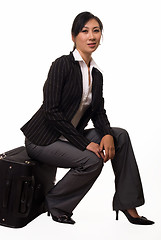 Image showing Woman sitting on luggage