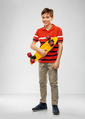 Image showing smiling boy with short skateboard