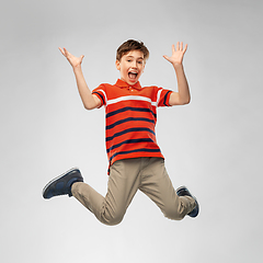 Image showing happy smiling young boy jumping in air