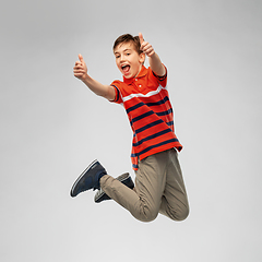 Image showing happy smiling young boy jumping in air