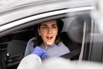 Image showing healthcare worker making coronavirus test at car