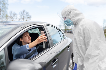 Image showing woman in car showing phohe to healthcare worker